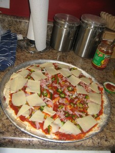 Pizza on its way.  Crust is from the Amish Market, we cheated with the sauce and bought some from the store, Kenny's KY Rose Cheese, and toppings include onions, bell peppers, jalapenos, banana peppers, ham and bacon!  We sprinkled a little Italian seasoning on the top!  First bake on a pizza sheet and then when almost finished transfer to a pizza stone to crisp up the crust!